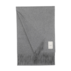 The Piacenza Cashmere Flannel Grey Aeternum Scarf, reminiscent of a luxurious fringed blanket, is folded neatly with its label proudly displayed against a pristine white background.