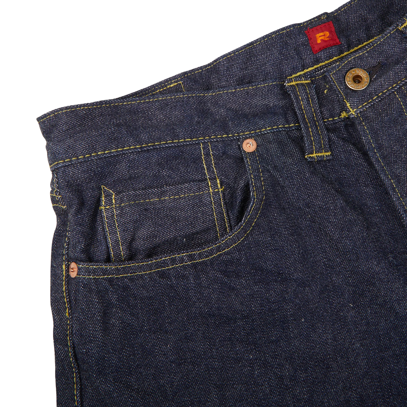 Close-up of dark blue cotton Resolute 714 One Wash jeans featuring detailed stitching and a front pocket with a visible red brand tag.