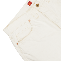 Close-up of a Resolute Cream Cotton Selvedge 714 One Wash Jeans pant featuring copper buttons and tan stitching, with a focus on the front pocket and waistband.