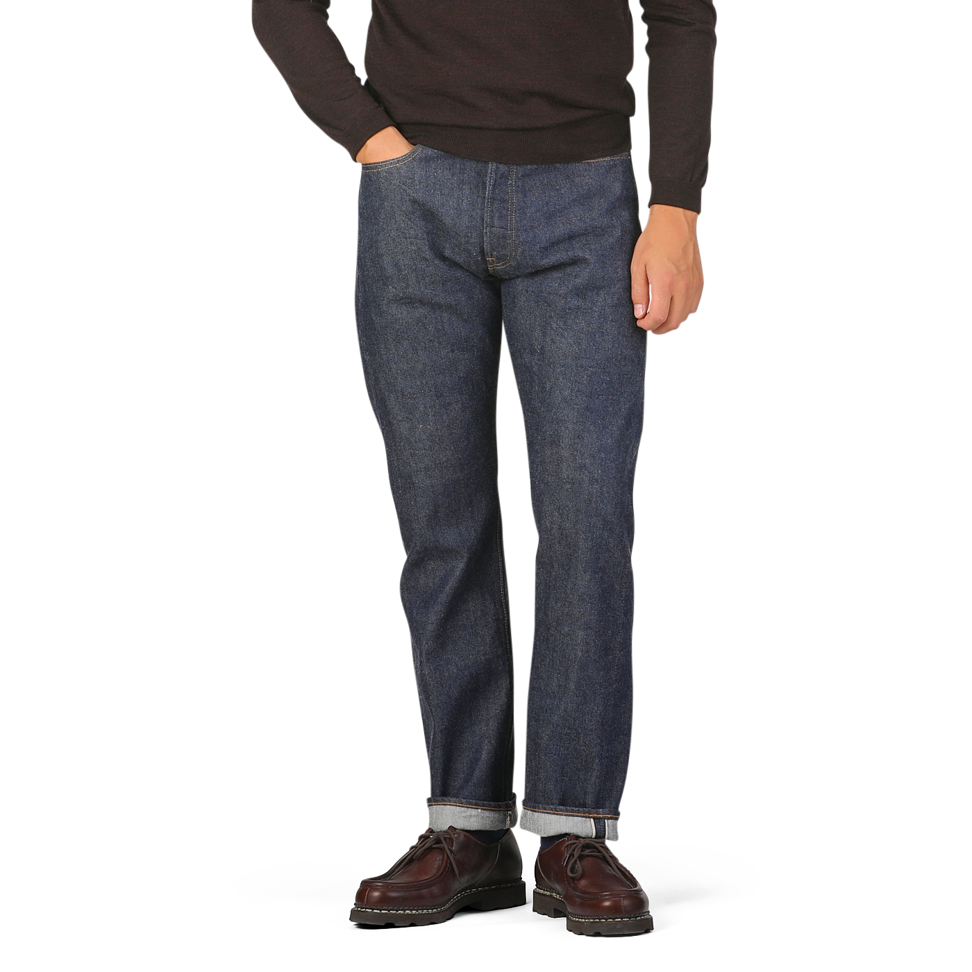 Person wearing a brown sweater with Dark Blue Cotton 710 One Wash Jeans by Resolute and brown shoes, standing against a plain background.