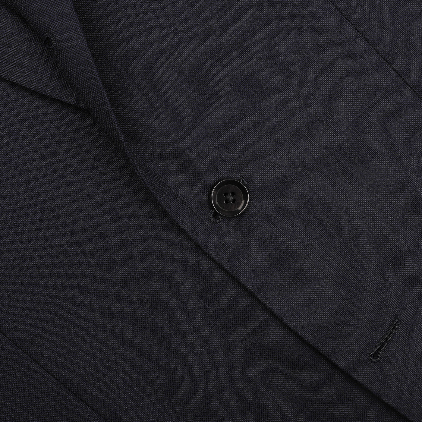 Close-up of the Navy Blue Calm Twist Wool Suit by Ring Jacket, showcasing a suit jacket made from high-twist wool fabric with a single black button and visible stitching detail.