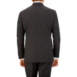 Rear view of a man in a Ring Jacket Dark Brown High Twist Wool Suit jacket and matching trousers, standing against a neutral background.