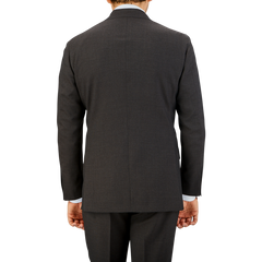 Rear view of a man in a Ring Jacket Dark Brown High Twist Wool Suit jacket and matching trousers, standing against a neutral background.