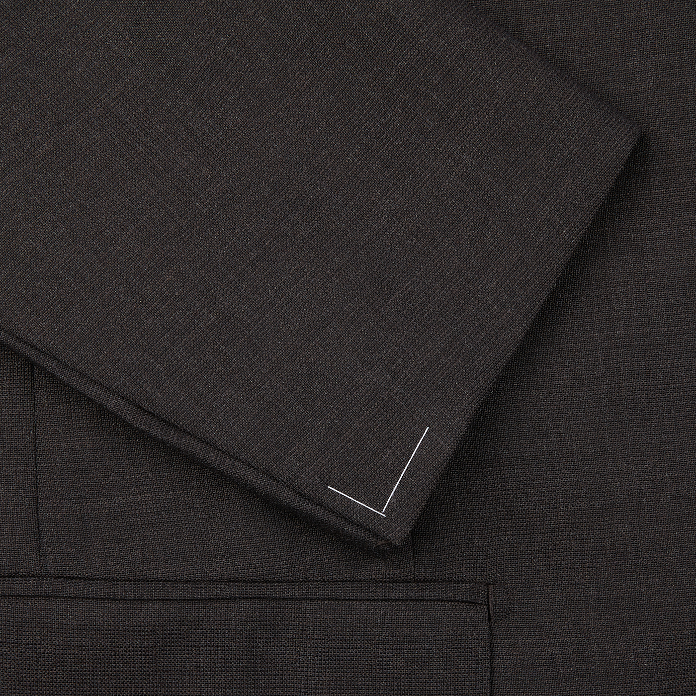 Close-up of Ring Jacket's dark brown high twist wool suit with visible weave pattern and white threads on the edge.
