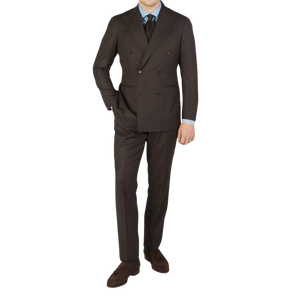 A man is gracefully posing in a Ring Jacket Dark Brown Wool Flannel DB Suit, tailored with pure wool flannel for impeccable comfort and showcasing a full canvas construction.