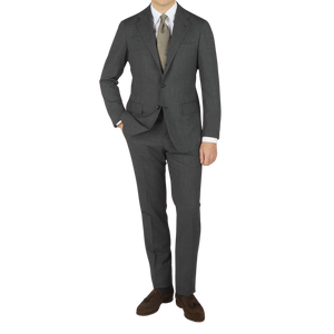 A man is posing in a Grey High Twist Wool Suit made by Ring Jacket.