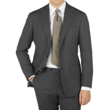 A contemporary version of a man wearing a Ring Jacket Grey High Twist Wool Suit, complete with a tie.