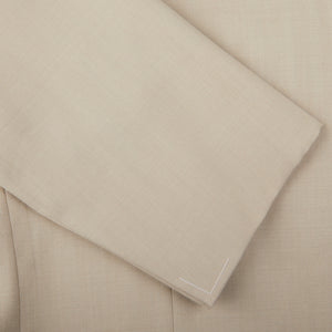 A close up image of a light beige Ring Jacket suit made of herringbone wool.