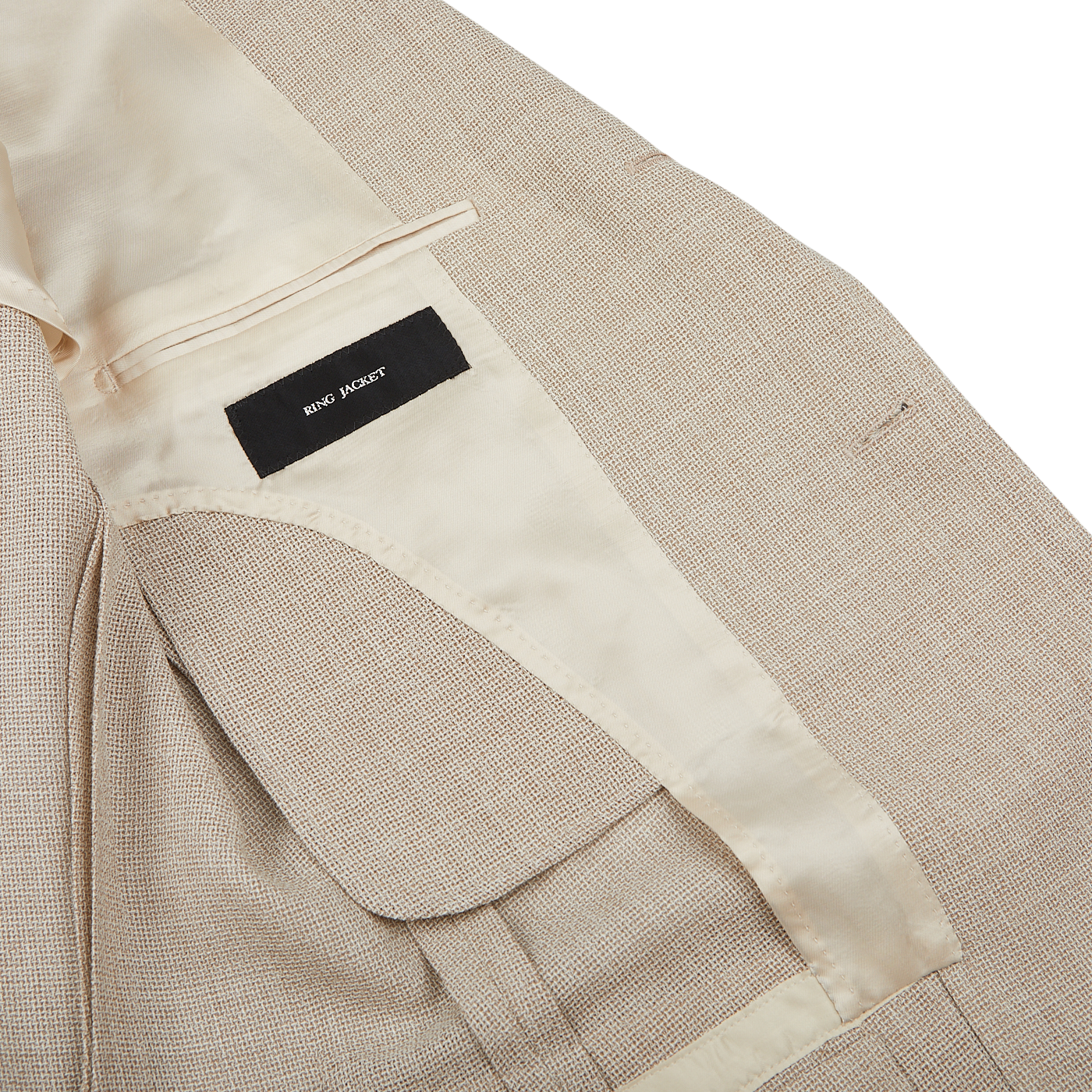 Close-up of a Light Beige Wool Balloon Travel Blazer with a visible inner pocket and a label reading "Ring Jacket" on a white background.