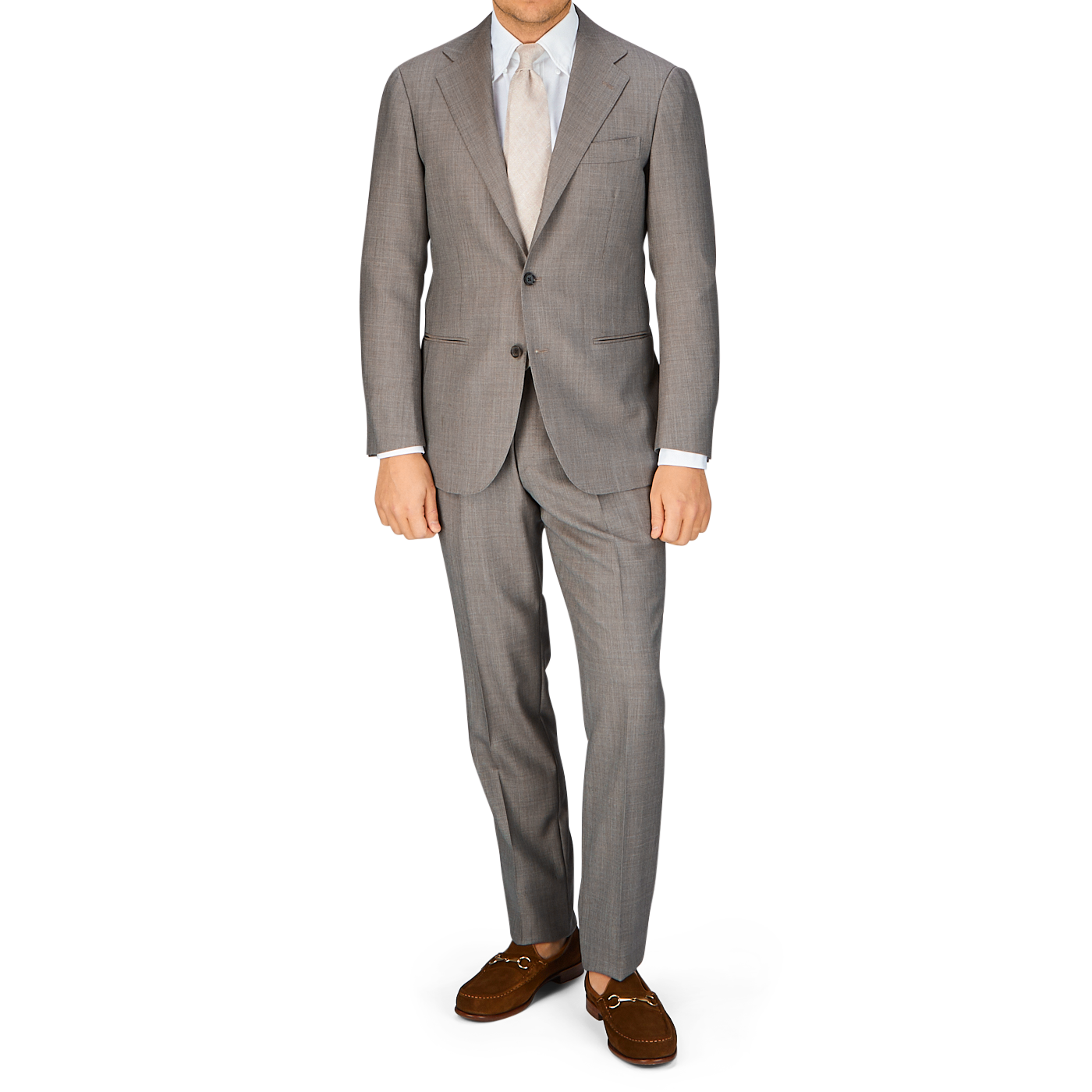Man standing in a Ring Jacket Mid Grey High-Twist Wool suit with a light shirt and brown shoes.