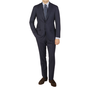 A man donning a Ring Jacket Navy Blue Herringbone Wool Suit made from pure virgin wool and a matching tie.