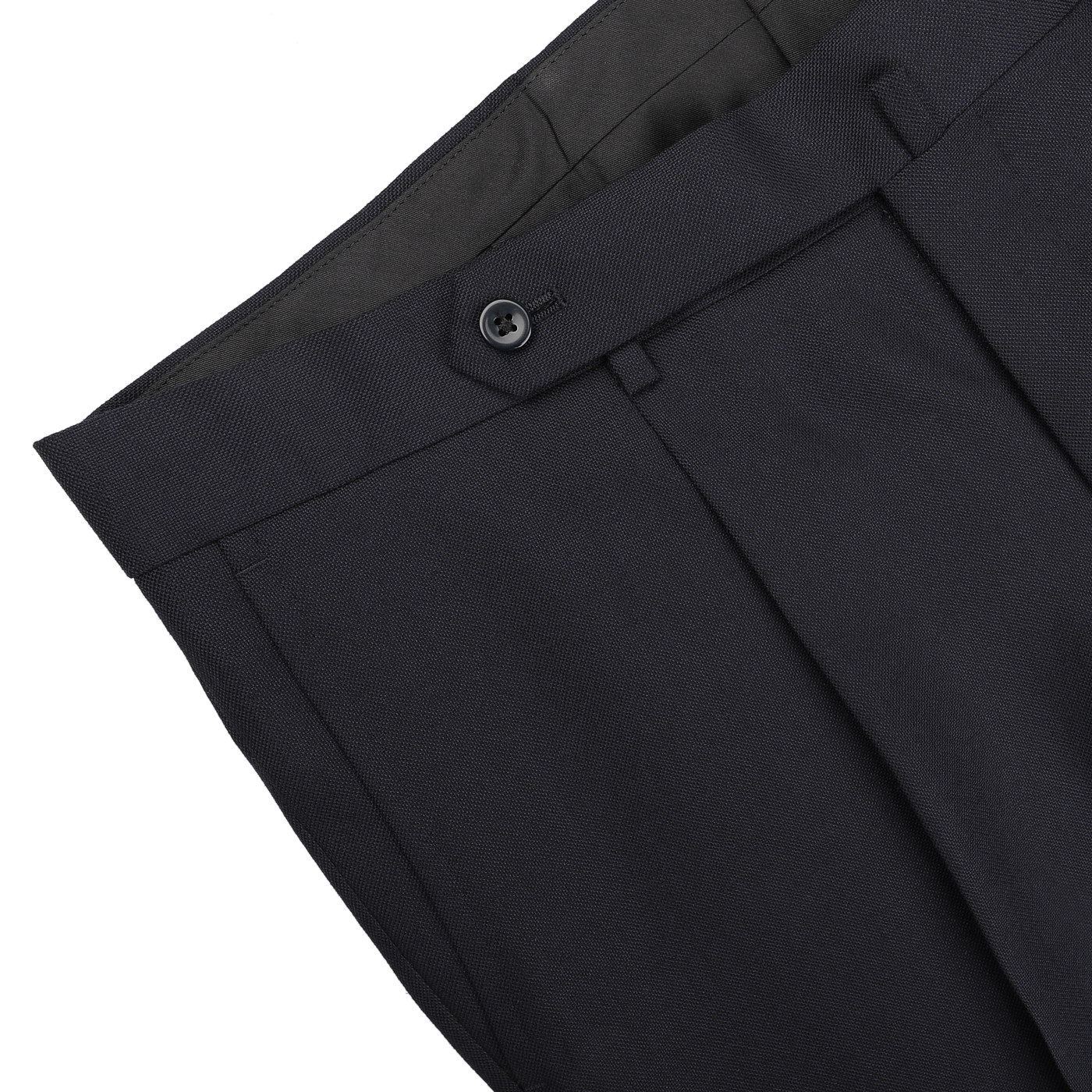 Close-up of a pair of trousers from the Navy Blue Calm Twist Wool Suit by Ring Jacket, crafted from high-twist wool fabric featuring a visible button and belt loop, displayed on a flat surface.