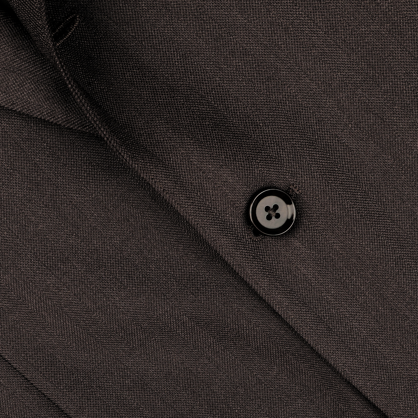 Close-up image of a black button on a Ring Jacket's Brown Herringbone Calm Twist Wool Suit.