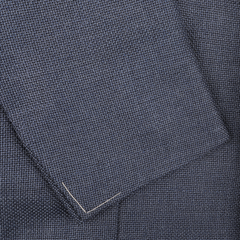 Close-up of the Denim Blue Wool Balloon Travel Blazer by Ring Jacket, showcasing a dark blue textured fabric with precise seam detail along the edge that highlights its exceptional craftsmanship.