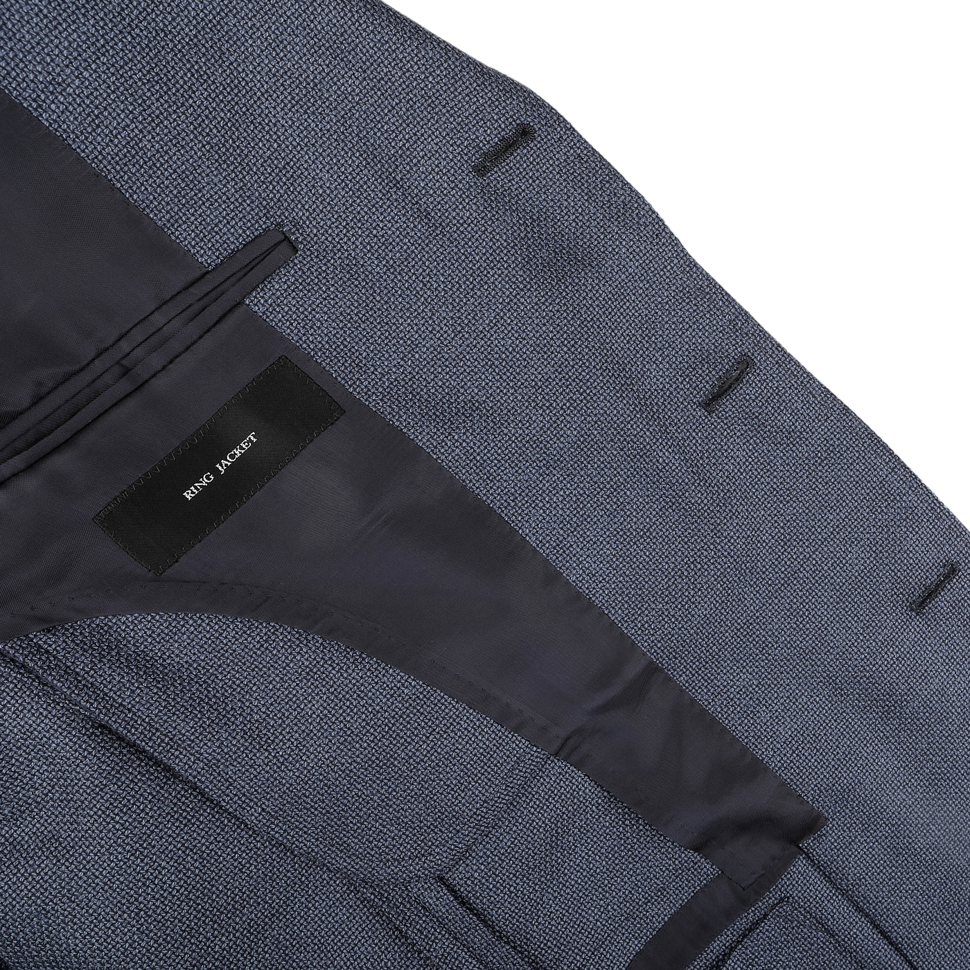 Close-up of the inside of a blue sports coat with a black label reading "Ring Jacket" and black lining, crafted from durable travel cloth.