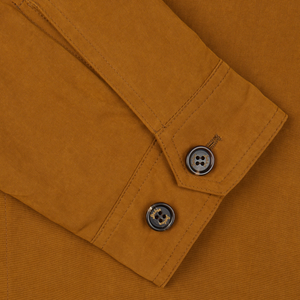 Close-up of a tobacco brown cotton Sealup Harrington waxed jacket with buttoned cuffs.