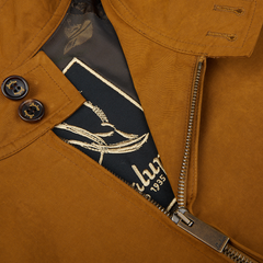 Close-up of a tobacco brown Cotton Harrington Waxed Jacket by Sealup with a partially unzipped zipper and a designer label visible.