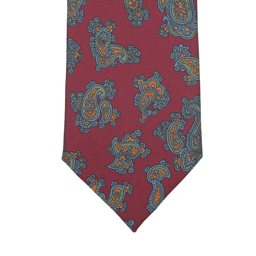 Close-up of a Seaward & Stearn Burgundy Paisley Printed Silk Tie, showcasing its luxurious handmade silk design with intricate blue and orange paisley patterns.