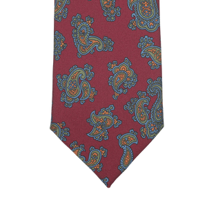 Close-up of a Seaward & Stearn Burgundy Paisley Printed Silk Tie, showcasing its luxurious handmade silk design with intricate blue and orange paisley patterns.