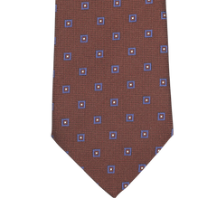 Close-up of Seaward & Stearn’s Cinnamon Brown Geometric Printed Silk Tie, featuring a stunning pattern of blue and orange squares and beautifully crafted by hand.