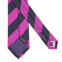 The Seaward & Stearn Fuschia Blue Striped Silk Tie, handmade in England, features diagonal purple and pink stripes with a label and care tag on the reverse side.