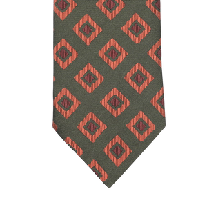 A Seaward & Stearn tie, known as the Green Orange Geometric Silk Tie, features a rich green background decorated with elegantly crafted red diamond shapes and intricate black geometric designs.