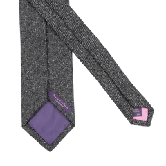 The Grey Blue Dot Wool Tie by Seaward & Stearn showcases a gray pattern with a purple lining, crafted from pure wool and featuring tags with brand details. Handmade in England, it combines elegance with a touch of distinction.