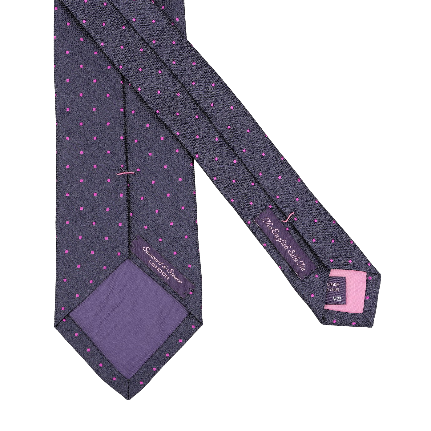 A navy blue silk tie by Seaward & Stearn, adorned with pink polka dots, featuring tags that indicate it is 100% silk and handmade in England.