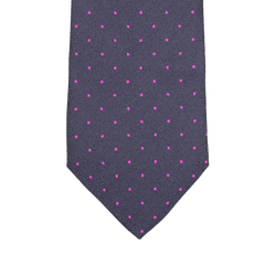 Close-up of a silk tie by Seaward & Stearn in a rich navy blue hue, featuring tiny pink dots woven into an elegant pattern.