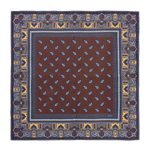 The Chocolate Recioto Silk Pocket Square by Sera Fine Silk is a square, brown paisley-patterned luxury silk pocket square, featuring intricate blue and yellow border detailing, made in Italy.