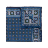 The Salt Primitivo Silk Pocket Square by Sera Fine Silk features intricate geometric patterns in shades of blue, green, and white, crafted from fine Como silk.