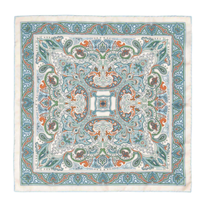 The Vernazza Cream Silk Pocket Square by Sera Fine Silk is a luxurious square piece of fabric adorned with an intricate pattern featuring blue, green, and orange paisley designs on a white background. Made from Como silk, this pocket square features hand-rolled edges for a refined finish.