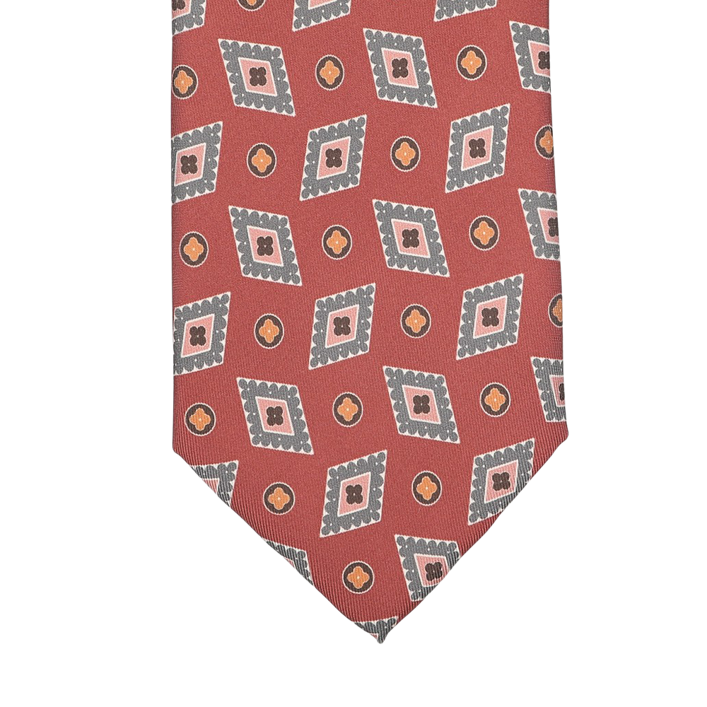 The Brick Red Diamond Printed Silk Lined Tie by Stefano Cau features a sophisticated geometric pattern of overlapping squares and circles in gray and orange, intricately woven into luxurious Italian Como silk. The rich brick red hue enhances the elegance of this exquisite accessory.