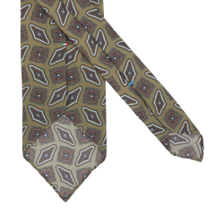 The Cactus Green Kilim Printed Silk Unlined Tie by Stefano Cau features a geometric design in brown, white, and red on a light olive background, crafted from luxurious Italian Como silk.