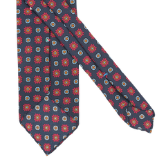 Introducing the Stefano Cau Dark Blue Flower Printed Silk Unlined Tie, meticulously crafted from luxurious Italian silk and adorned with a delightful pattern of red and yellow flowers complemented by small square motifs.