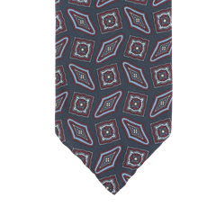 A close-up of a Stefano Cau necktie crafted from luxurious Italian silk, featuring a geometric pattern with red, blue, and white diamond and square shapes on a dark gray background.