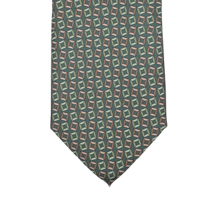 A close-up of a Stefano Cau Grass Green Square Printed Silk Lined Tie, featuring a geometric pattern with interlocking shapes in green, blue, and tan hues.