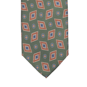 Made from luxurious Italian Como silk, the Green Diamond Printed Silk Lined Tie by Stefano Cau features a geometric design with brown-bordered diamonds and small blue circles.