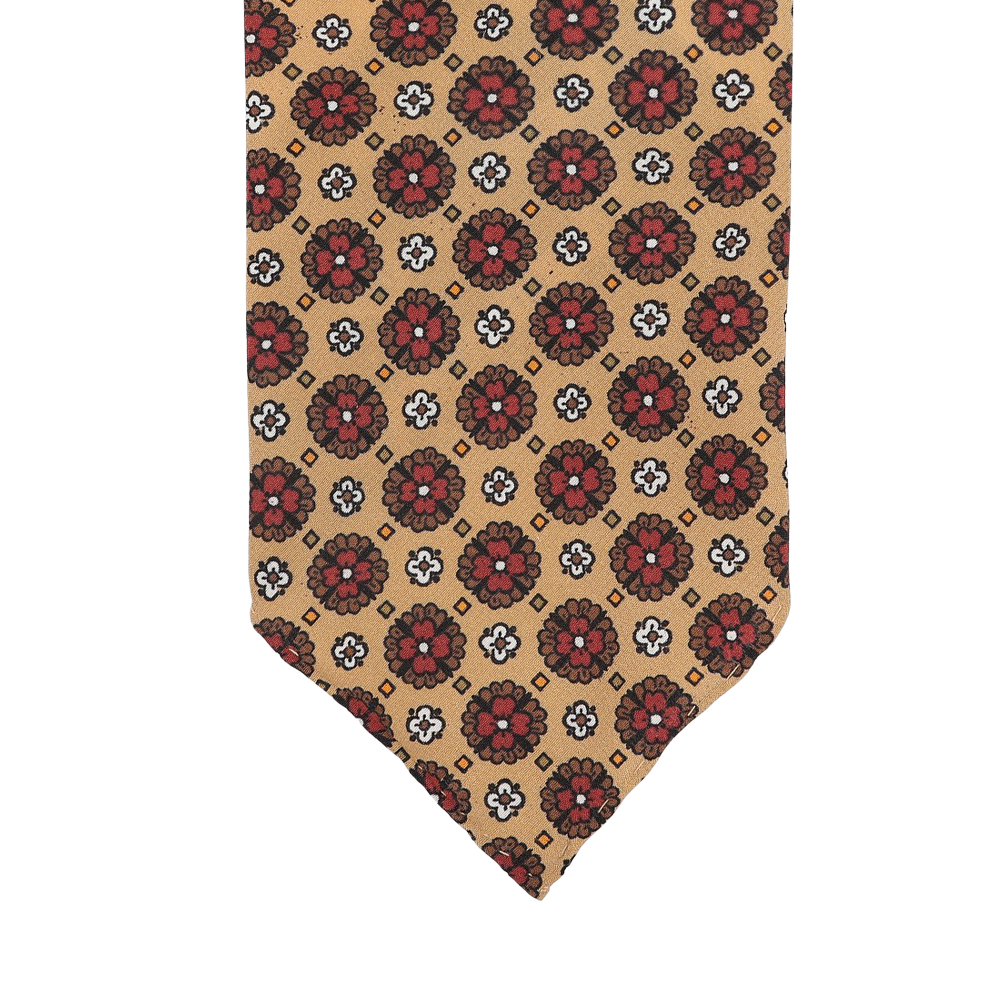 This Stefano Cau tie, crafted from luxurious Italian Como silk, showcases a beige design embellished with red and black floral patterns.