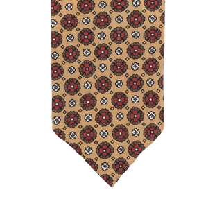 This Stefano Cau tie, crafted from luxurious Italian Como silk, showcases a beige design embellished with red and black floral patterns.