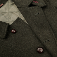 Detailed view of the Dark Green Wool Alpaca Loden Coat by Steinbock, highlighting its leather football buttons, quilted lining, and buttonhole detail on the collar.