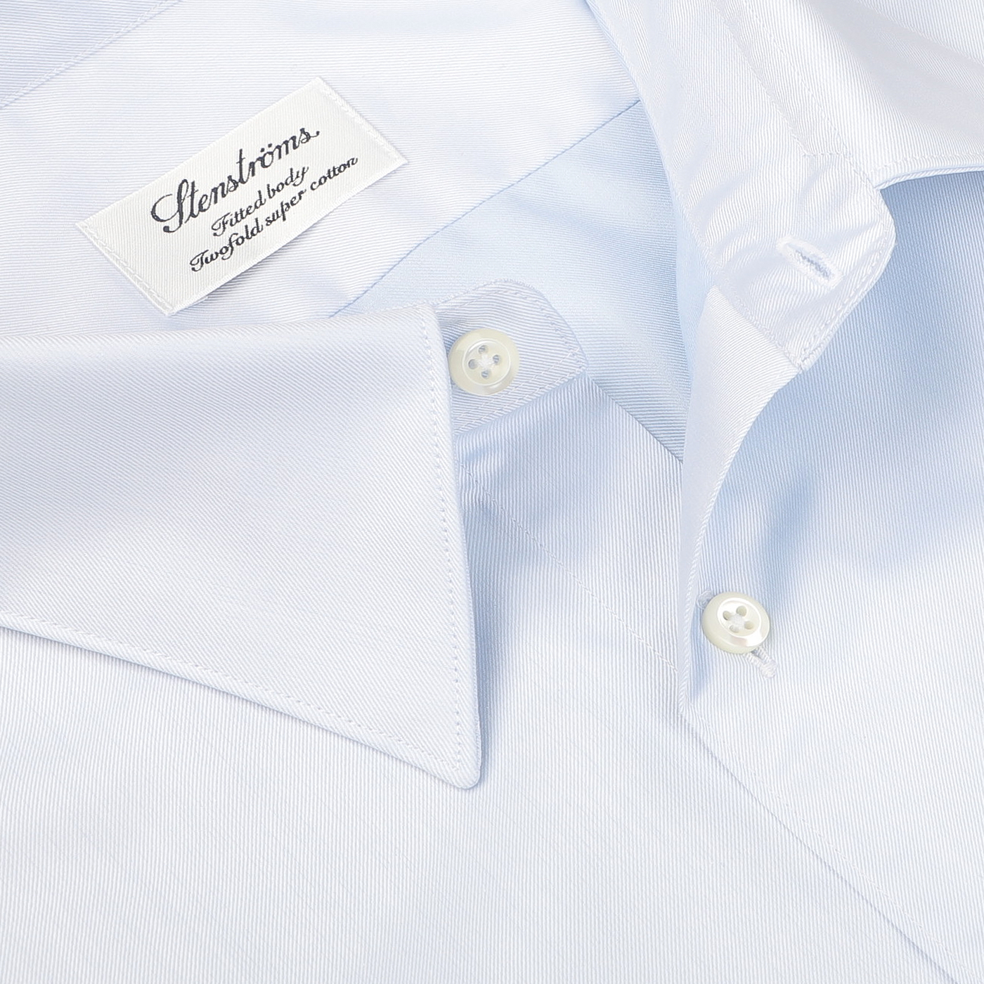 Close-up of a light blue formal shirt labeled "Stenströms, Made in Sweden, Twofold super cotton." This Light Blue Cotton Twill Fitted Body Shirt is made from pure cotton twill and features a fitted body cut with two buttons on the collar.