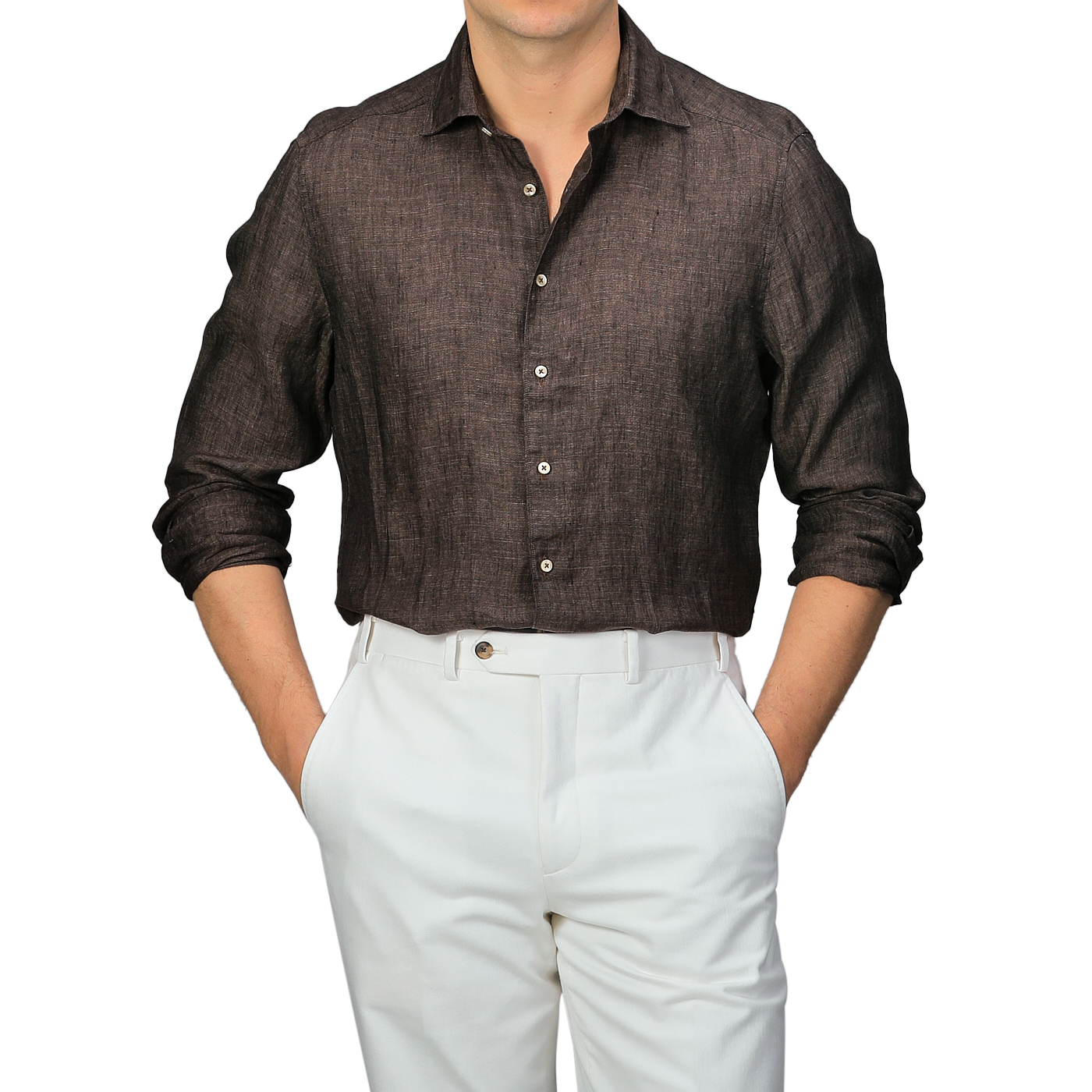 The person is showcasing a stylish Stenströms Dark Brown Linen Cutaway Slimline Shirt with sleeves rolled up, paired elegantly with white pants. This summer essential exudes a relaxed yet chic look, hands casually in pockets.