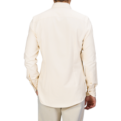 A person wearing a Cream Cotton Flannel Slimline BD Shirt from Stenströms and light, slim-fit trousers is shown from the back.