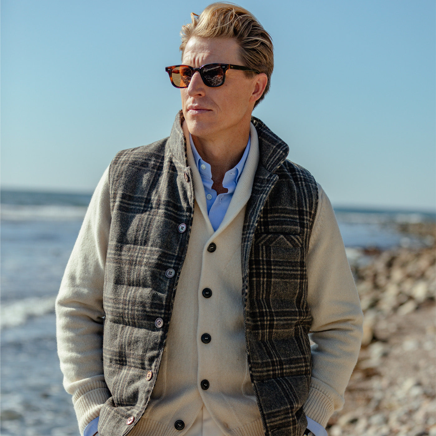 A man wearing a Stenströms Beige Checked Wool Down Padded Gilet on the beach.