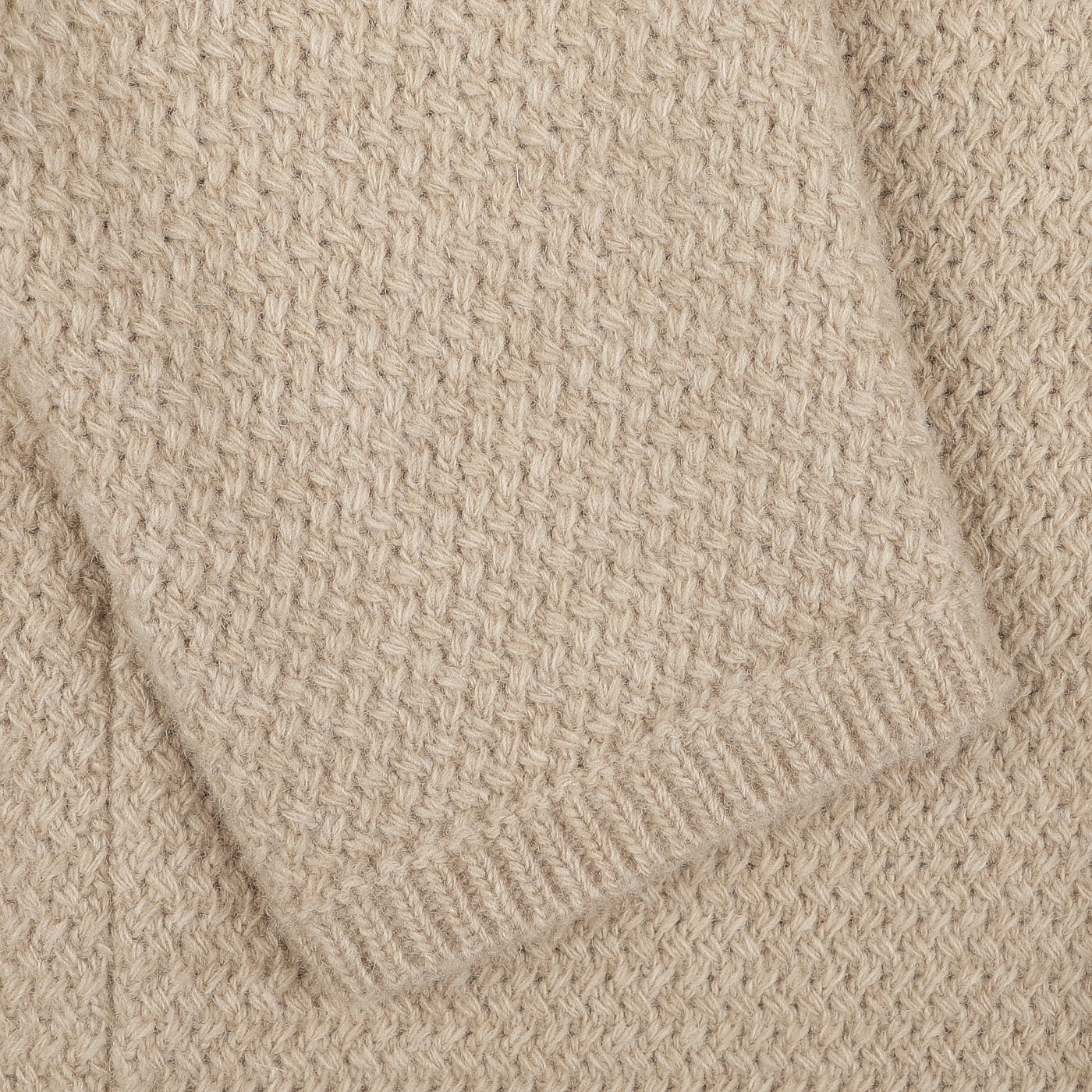 Close-up of the Beige Merino Wool Knitted Blazer by Stenströms, featuring a textured, woven pattern and highlighting a folded section in the upper left corner.