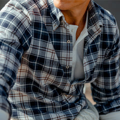 A man in a slim fit, Blue Checked Cotton Flannel Slimline Stenströms shirt is sitting on a bench.