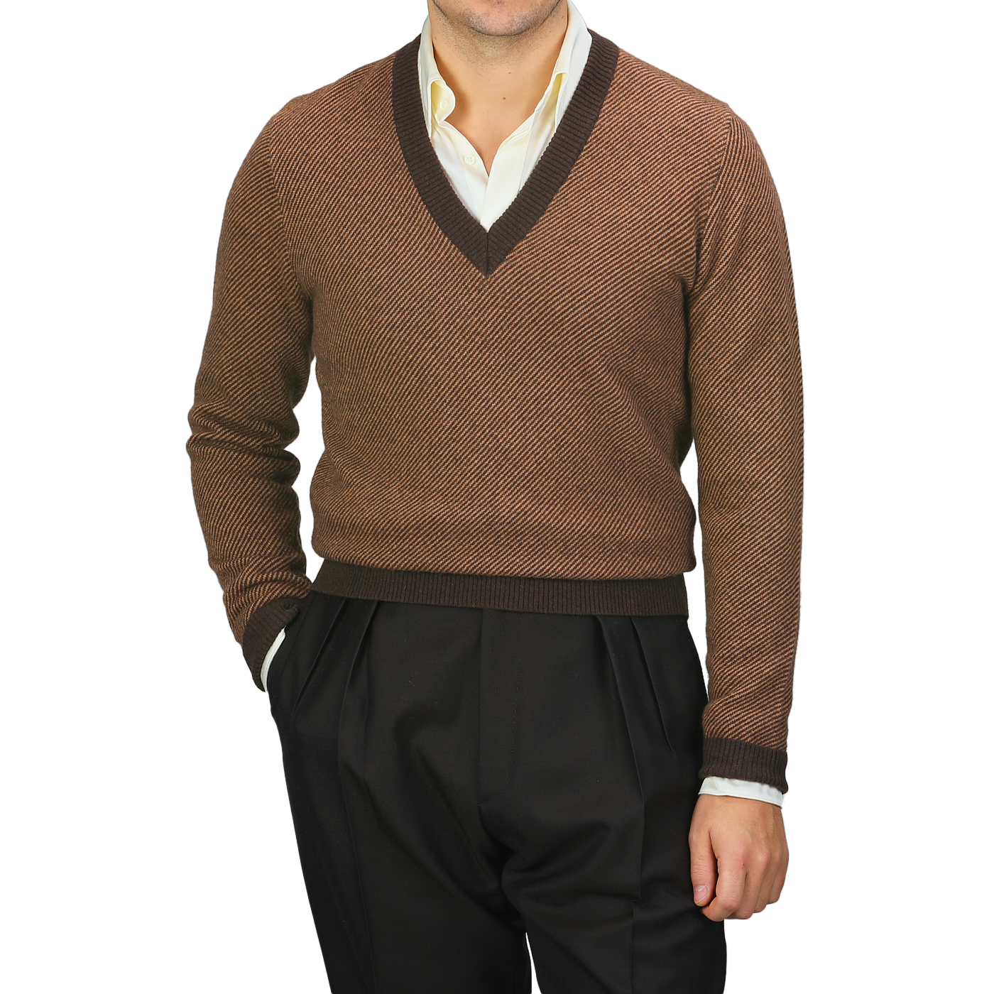 Dressed in a camel brown striped merino V-neck sweater by Stenströms over a crisp white shirt, the individual pairs this ensemble with sleek black pants, hands casually tucked into pockets.