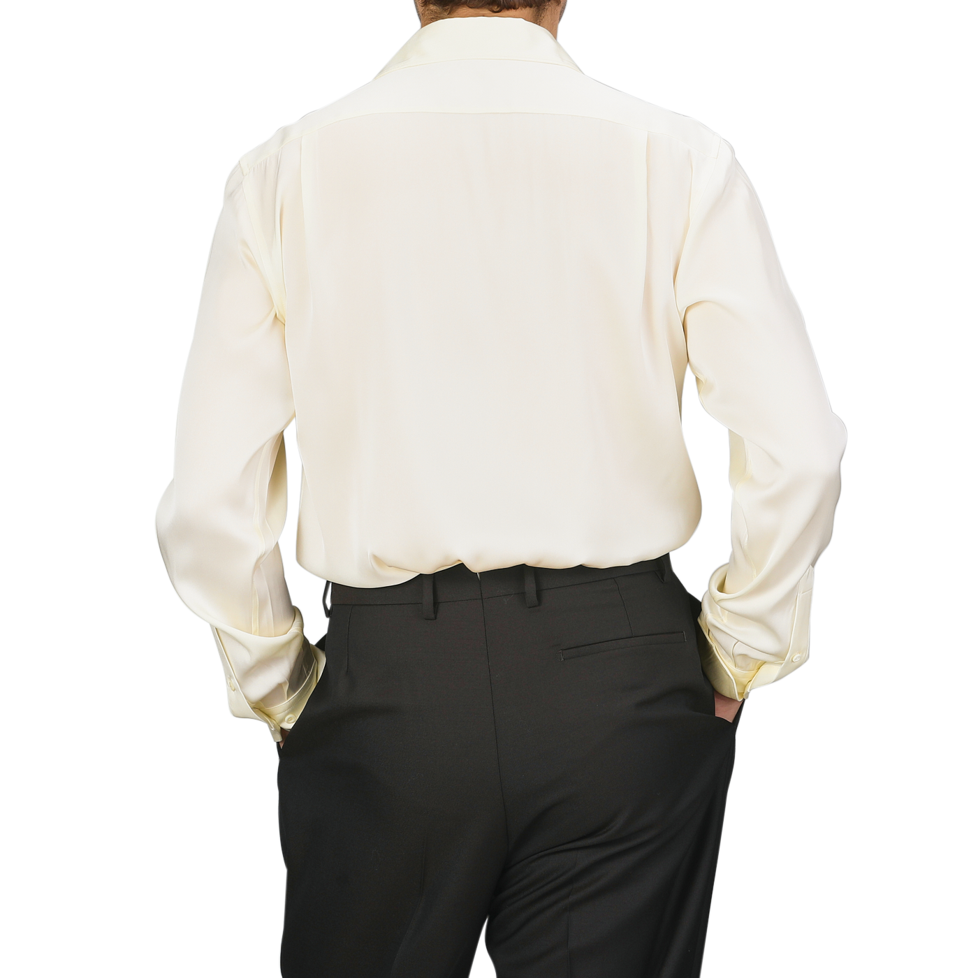 Individual dressed in a Cream Silk Fitted Body Shirt by Stenströms and black pants, facing away from the camera with hands tucked into pockets.