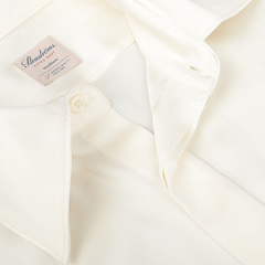 Close-up of the Cream Silk Fitted Body Shirt by Stenströms, featuring an off-white hue, fitted silhouette, button-down collar, and a visible brand label as part of our capsule collection.